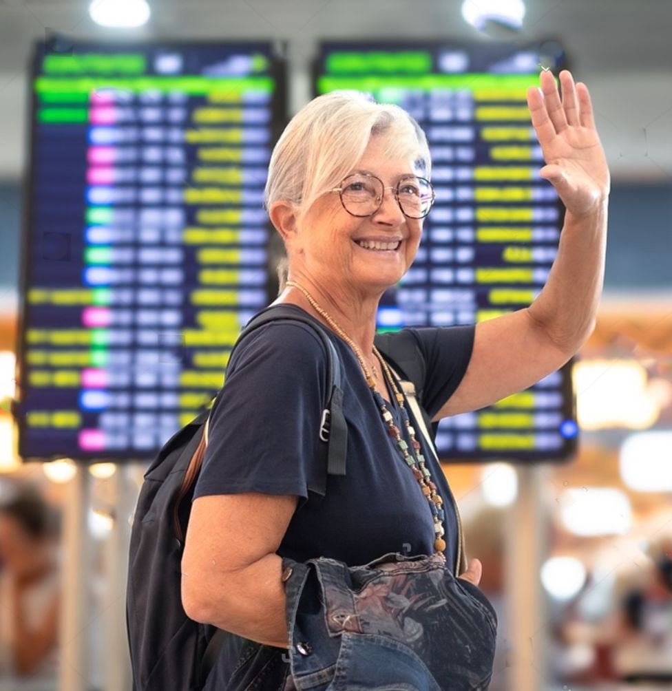 An older woman with gray hair and glasses smiles and waves while standing in front of airport flight information screens. She wears a backpack and holds a jacket, looking cheerful and ready to travel. Une femme âgée aux cheveux gris et portant des lunettes sourit et fait un signe de la main devant des écrans d’information sur les vols dans un aéroport. Elle porte un sac à dos et tient un manteau, ayant l’air joyeuse et prête à voyager.